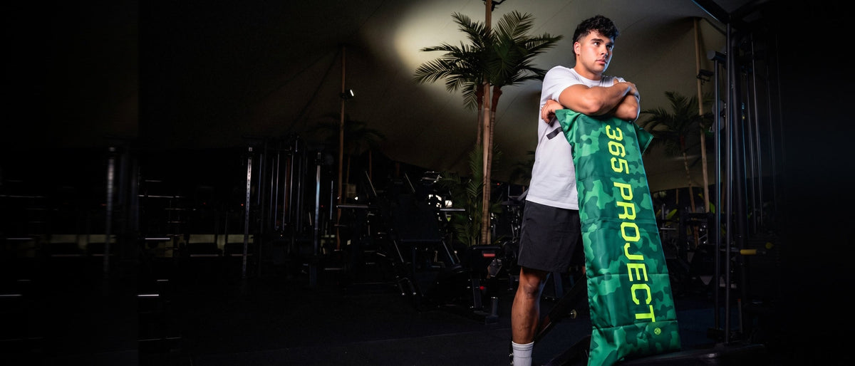 Atleta en el gimnasio con su toalla 365 PROJECT verde de camuflaje